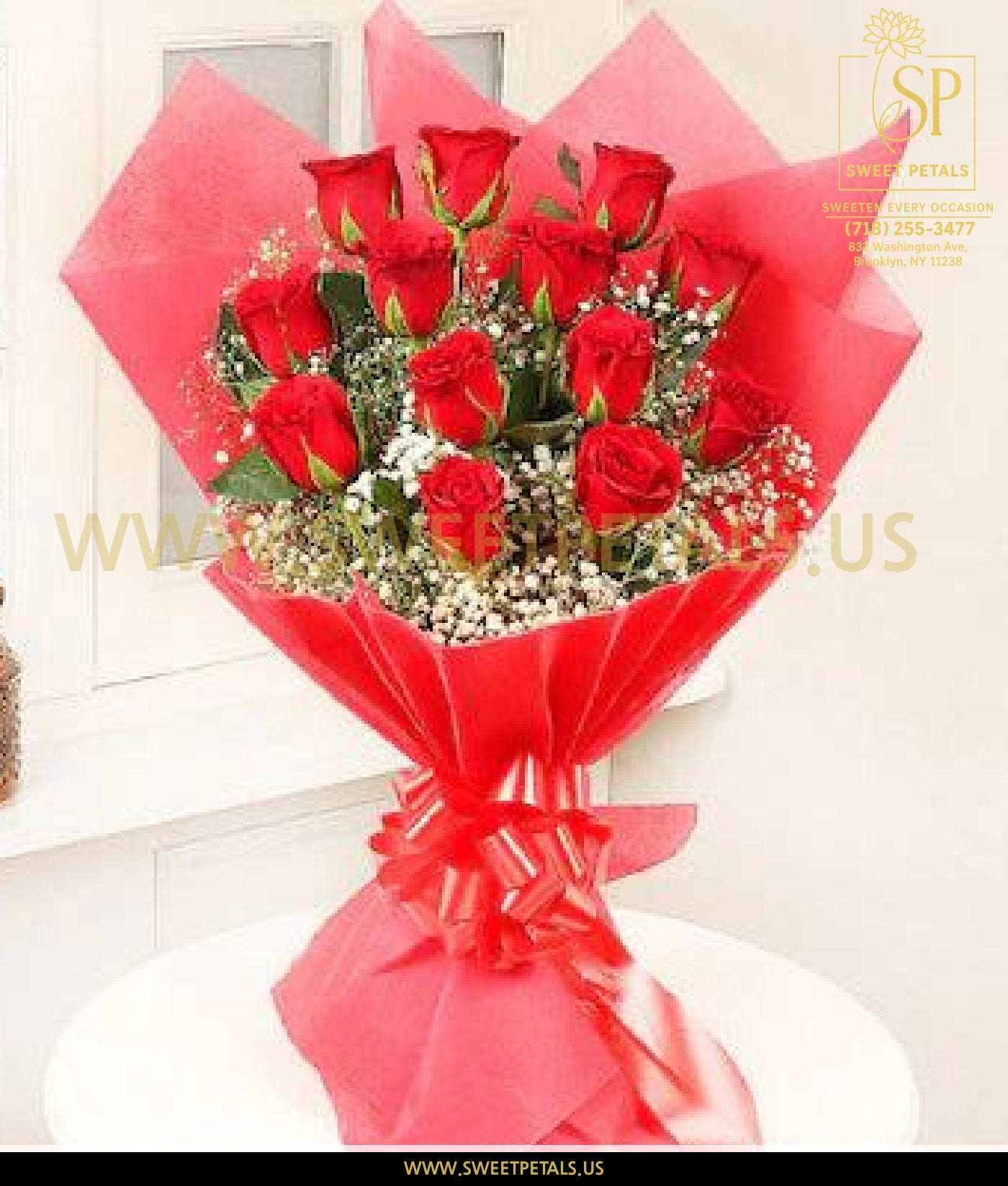 Elegant bouquet of fresh red roses with white baby’s breath, wrapped in red floral paper and tied with a matching ribbon, perfect for romantic occasions.