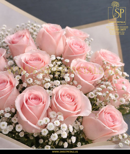 Dozen pink roses delivered in an elegant bouquet with baby’s breath, showcasing fresh pink roses arranged for classic dozen roses delivery.