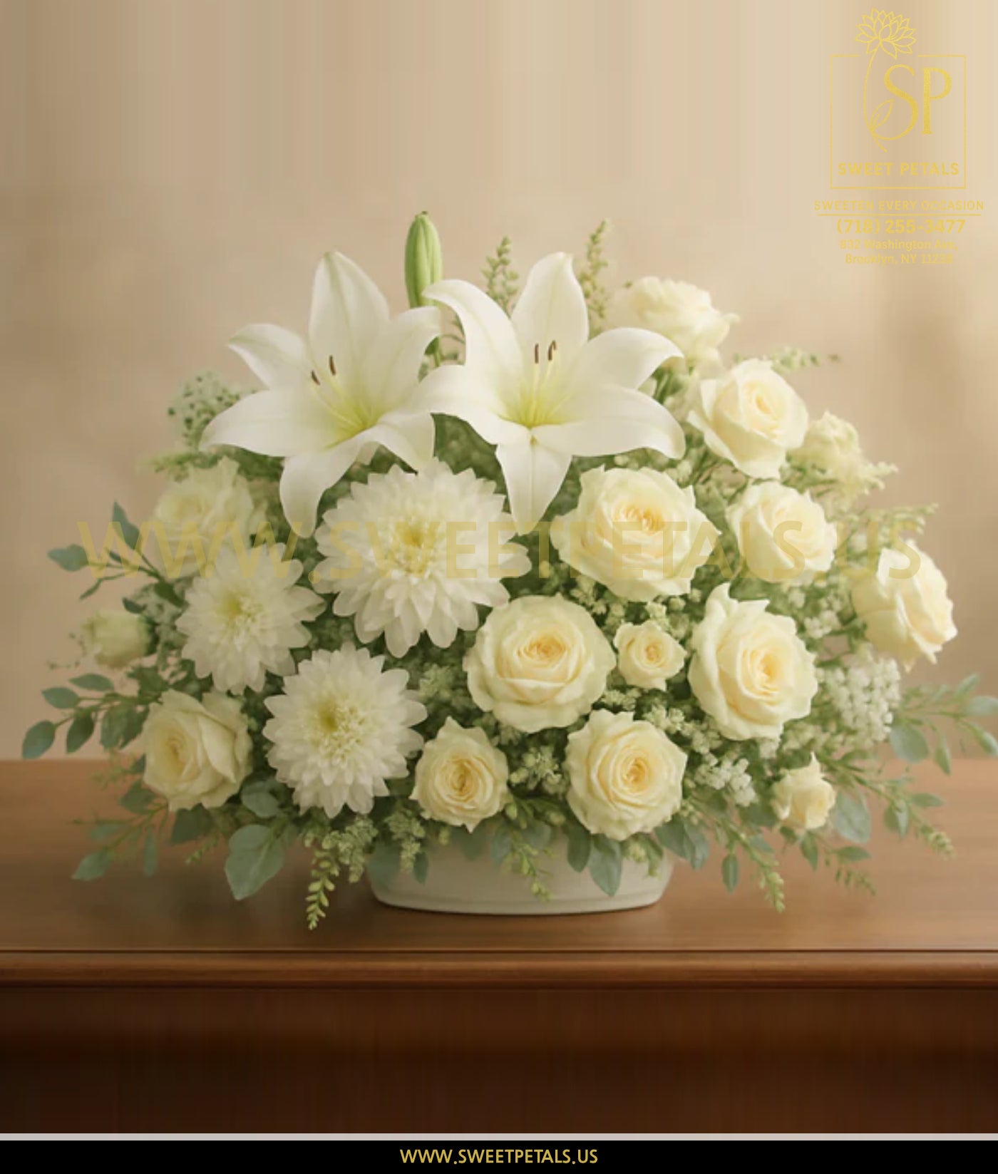 Bouquet of white flowers in a vase on a wooden surface with a beige background.