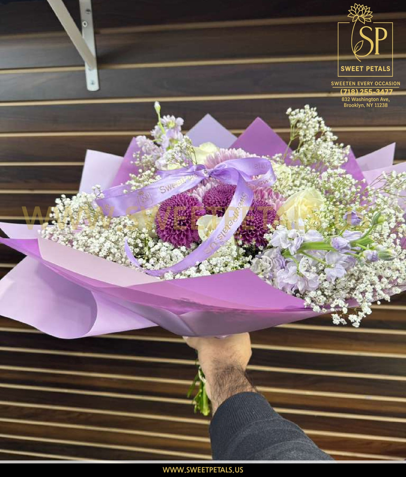 Mixed bouquet of flowers in soft lavender wrapping featuring purple blooms, white roses, and baby’s breath – a delicate lavender bouquet from the Bliss Bouquets collection.