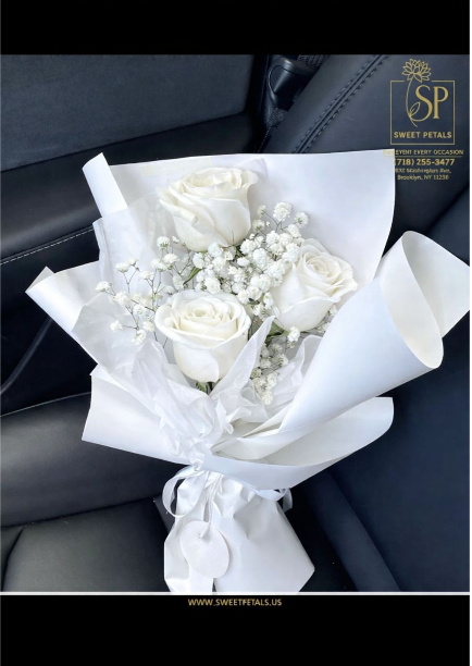Valentine flowers bouquet with white roses wrapped in white paper, simple and elegant arrangement suitable as funeral roses or a meaningful Valentine gift.