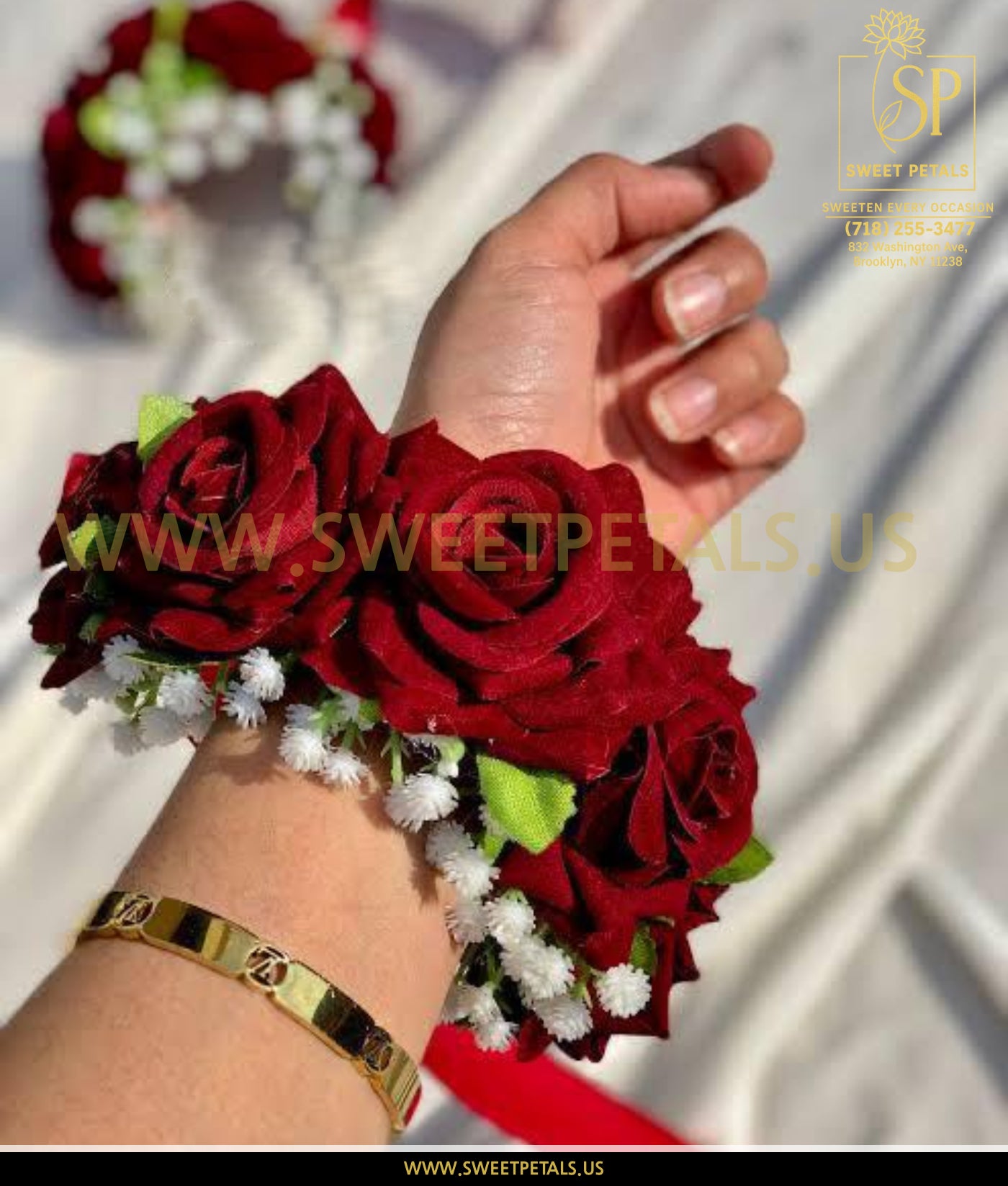 Red wrist corsage made with fresh red roses and white filler flowers, elegant wrist corsage and red rose corsage worn on the wrist for special occasions.