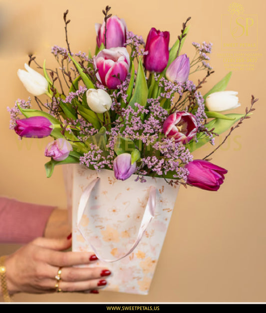 Bouquet of colorful tulips held by a hand with a beige background