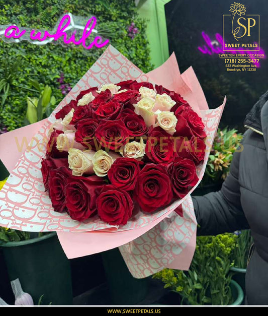 Elegant bouquet of red and white roses wrapped in soft pink paper, perfect to send Valentine’s flowers with fast Valentine’s roses delivery.