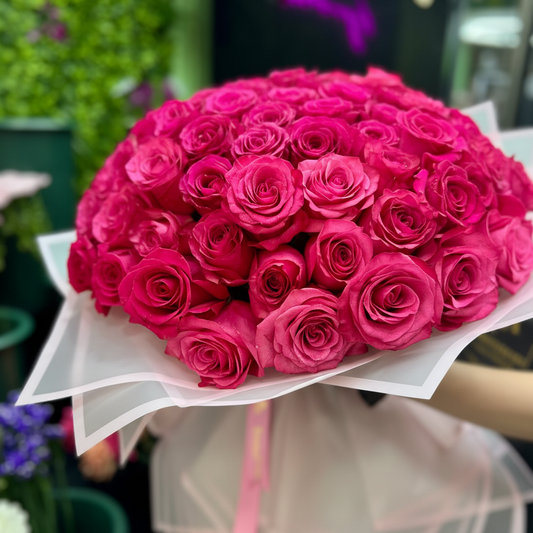 Close-up of 50 hot pink fuchsia roses in perfect dome formation in white organza wrap – SweetPetals grand romantic bouquet