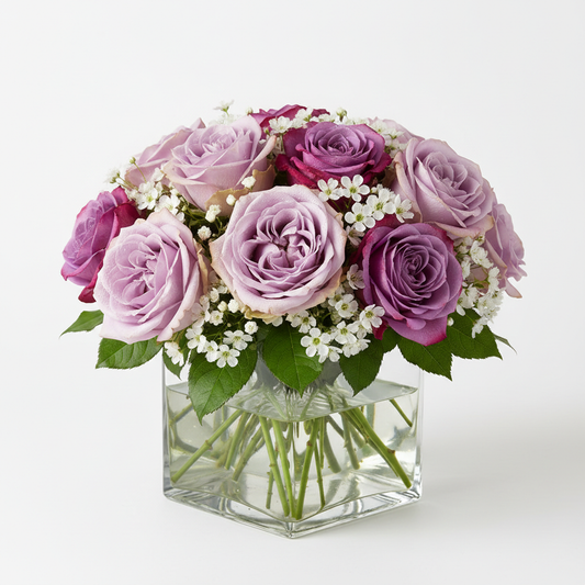 Close-up of lavender and purple roses with white filler in glass vase – SweetPetals NYC florist