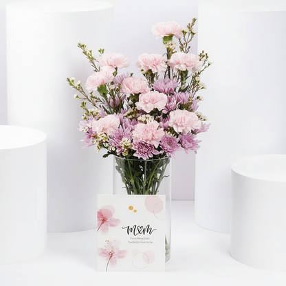 Pink carnations and purple chrysanthemums in glass vase with M&M greeting card – SweetPetals NYC florist